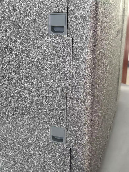 Close-up of a textured gray surface with two small rectangular cutouts.