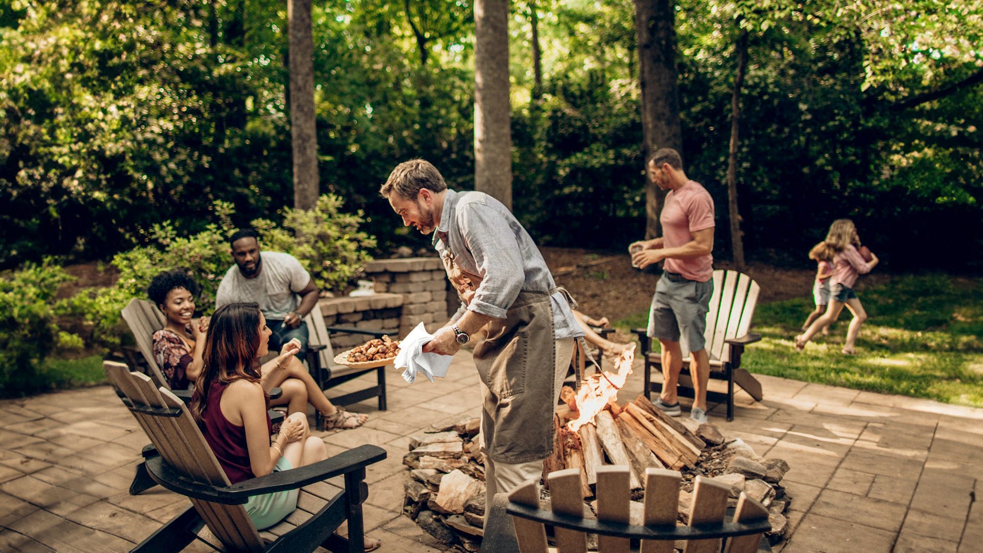 Family gathered around a fire pit in a backyard setting